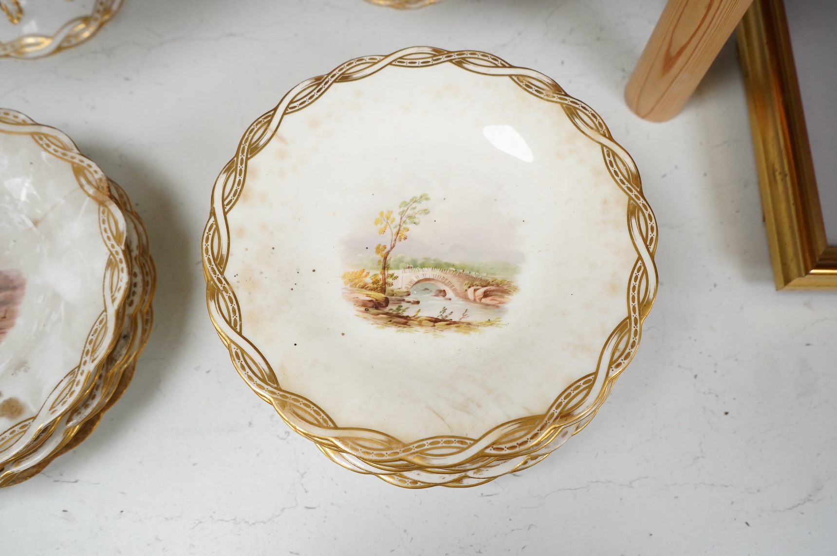 A Late 19th century Minton porcelain part dessert service, each piece painted with differing landscapes, largest 28cm in diameter